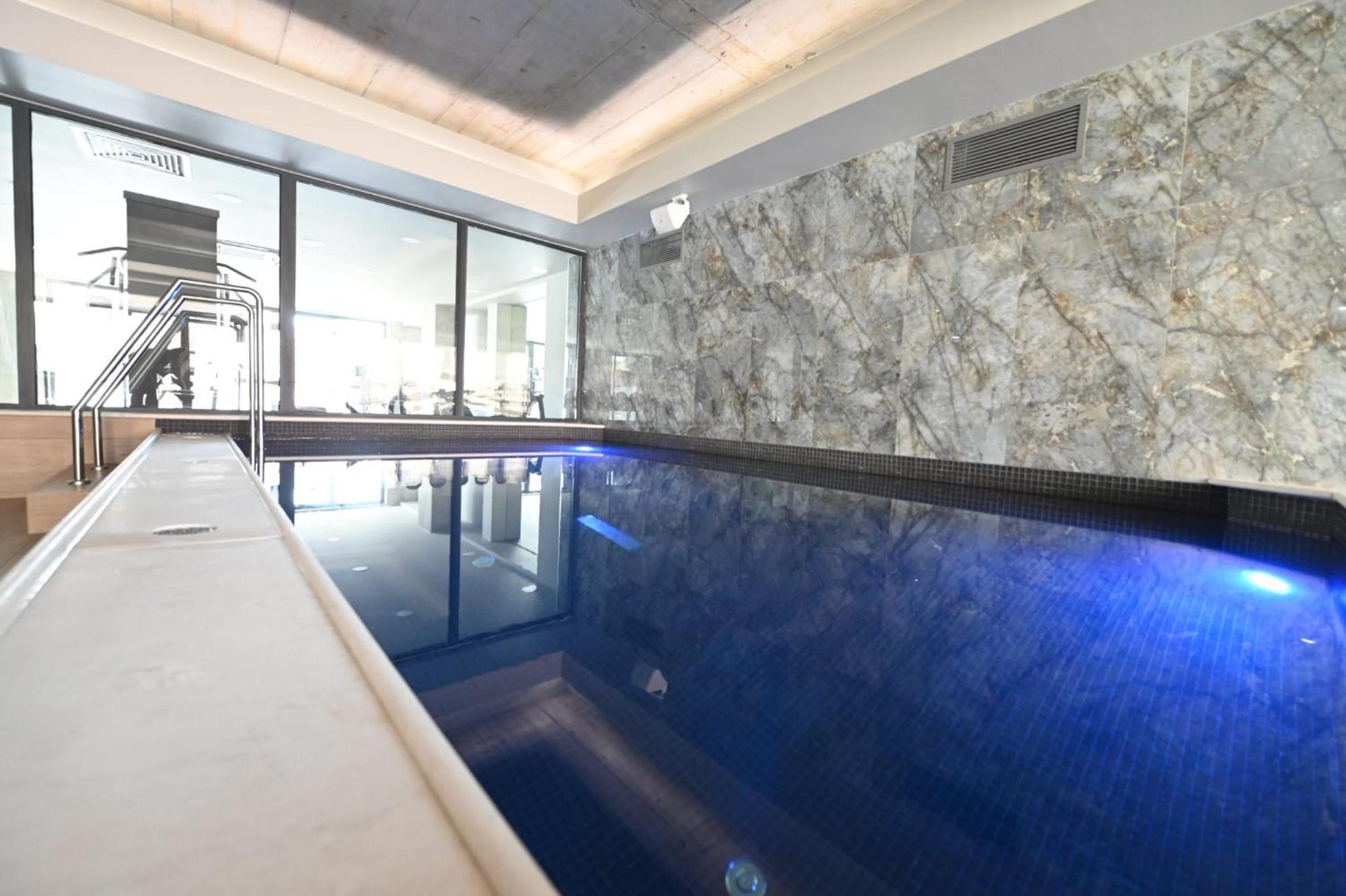 Aniroc Signature Hotel Arad Bagian luar foto A pool with a glass wall