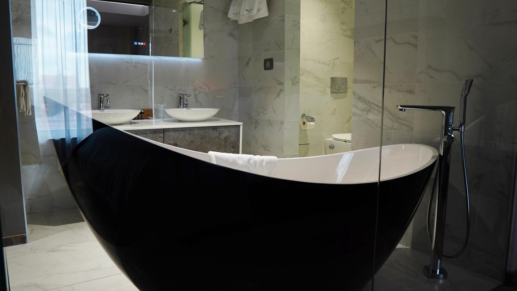 Aniroc Signature Hotel Arad Bagian luar foto A freestanding bathtub