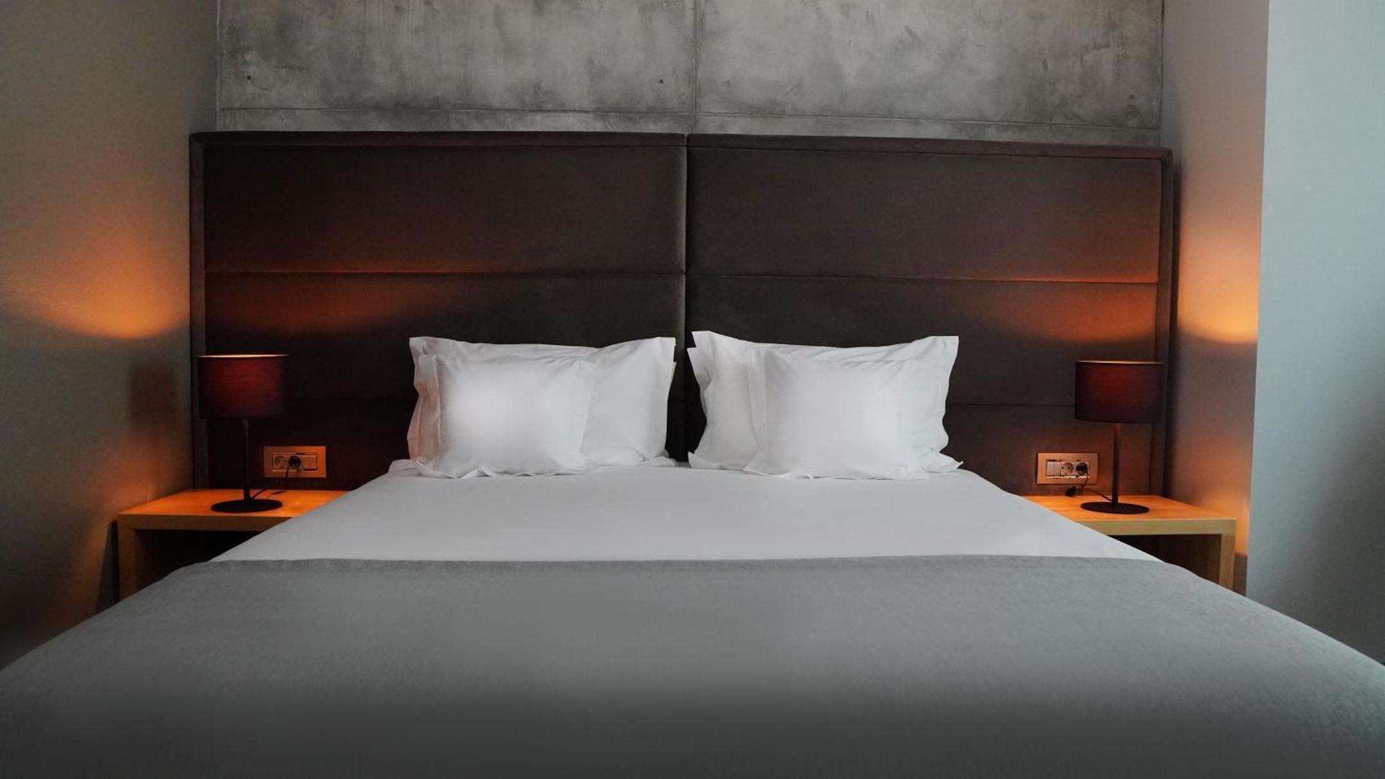 Aniroc Signature Hotel Arad Bagian luar foto A bed with two pillows
