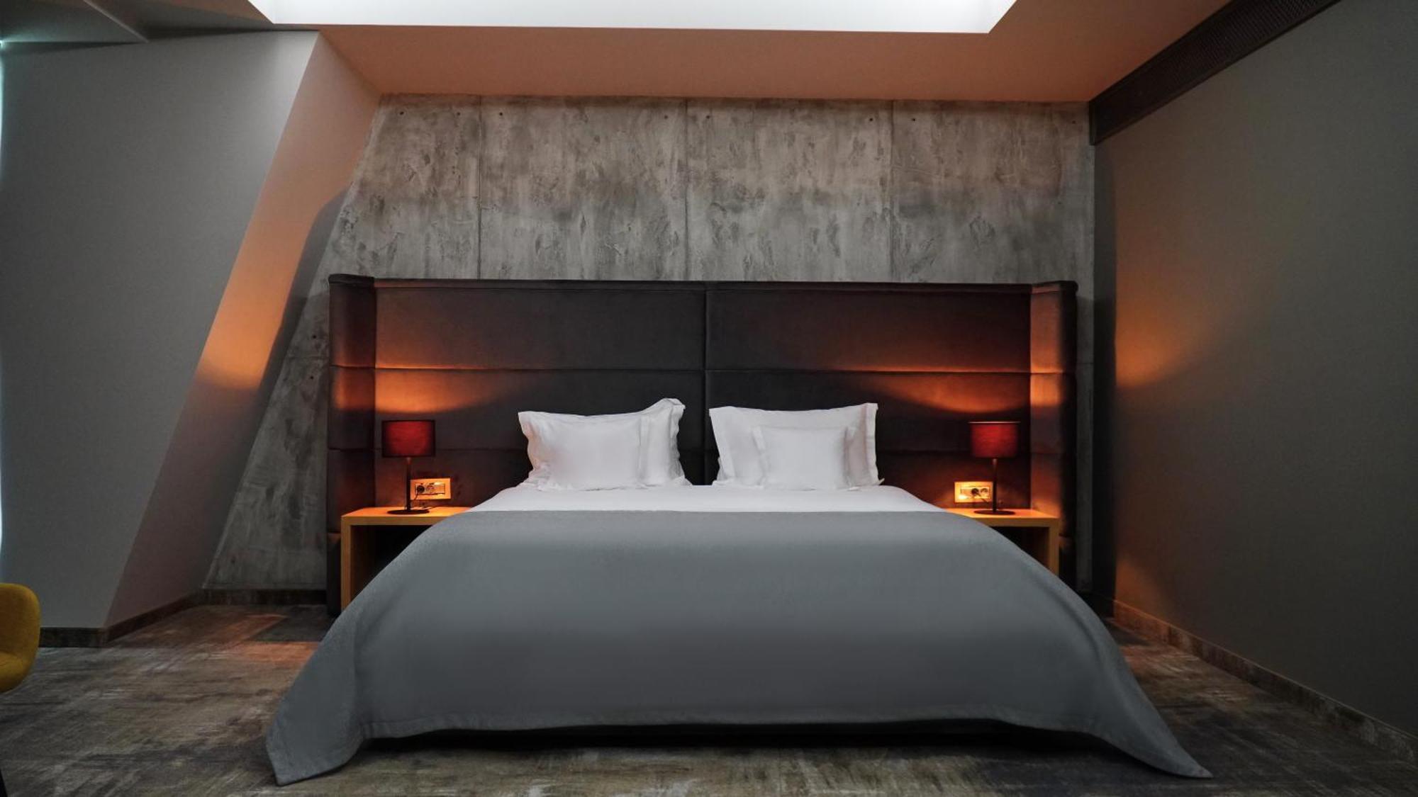 Aniroc Signature Hotel Arad Bagian luar foto A bed with a duvet